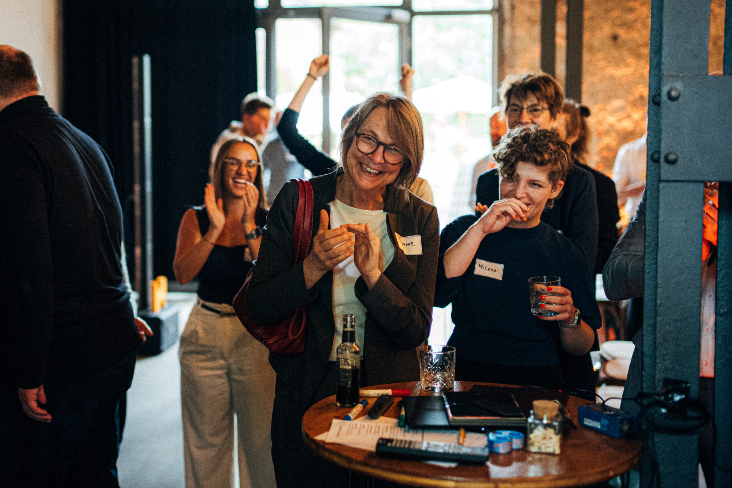 Fröhliche, feiernde Mitarbeiterinnen auf einem Unternehmensevent.