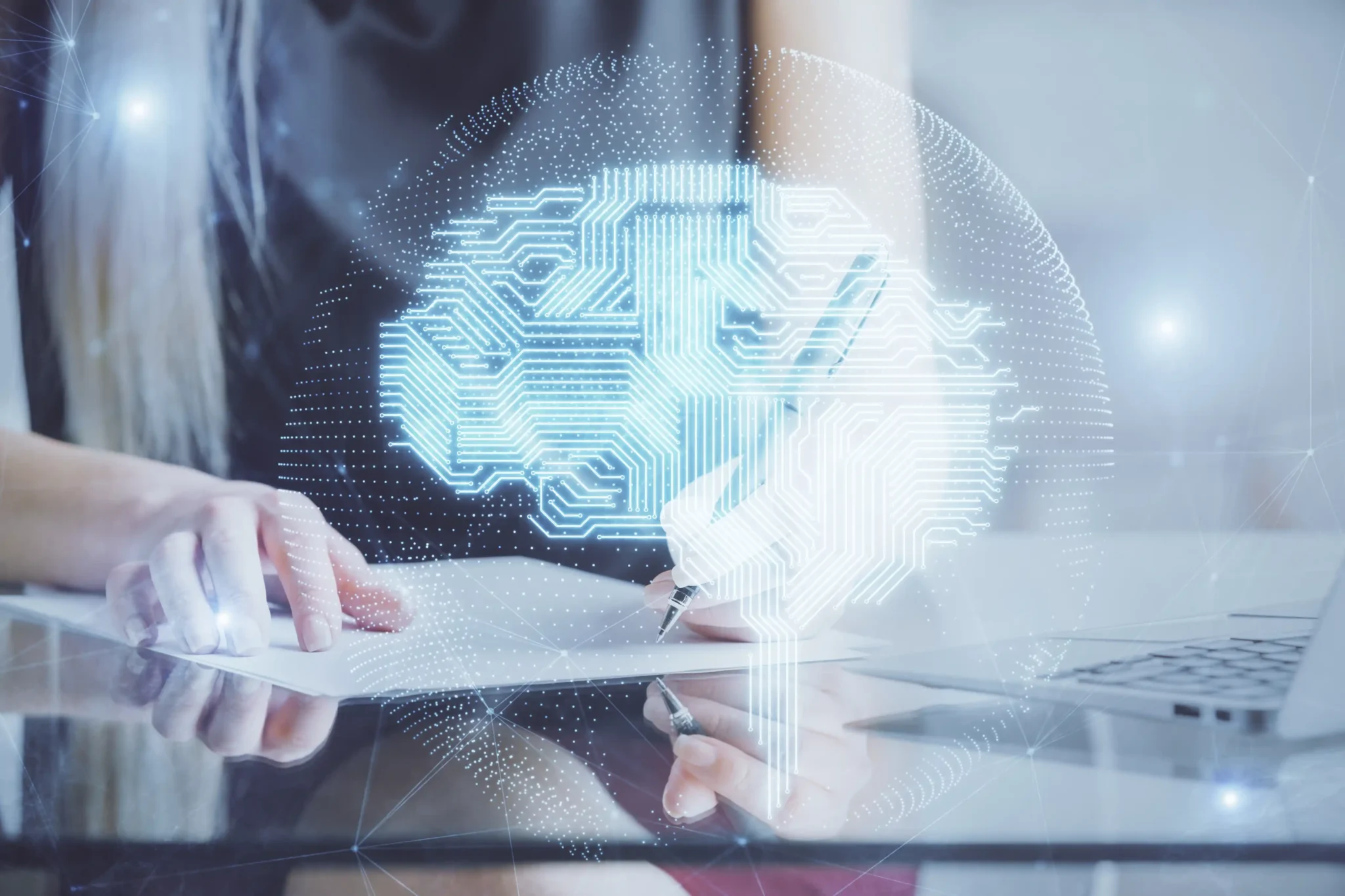 Person arbeitet am Laptop, darüber ist eine digitale Illustration eines vernetzten Gehirns als Symbol für Künstliche Intelligenz und KI-Beratung eingeblendet.